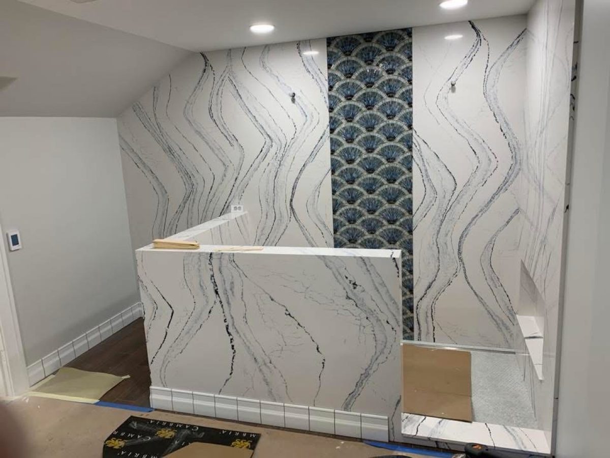 Marble shower with blue scallop accent wall
