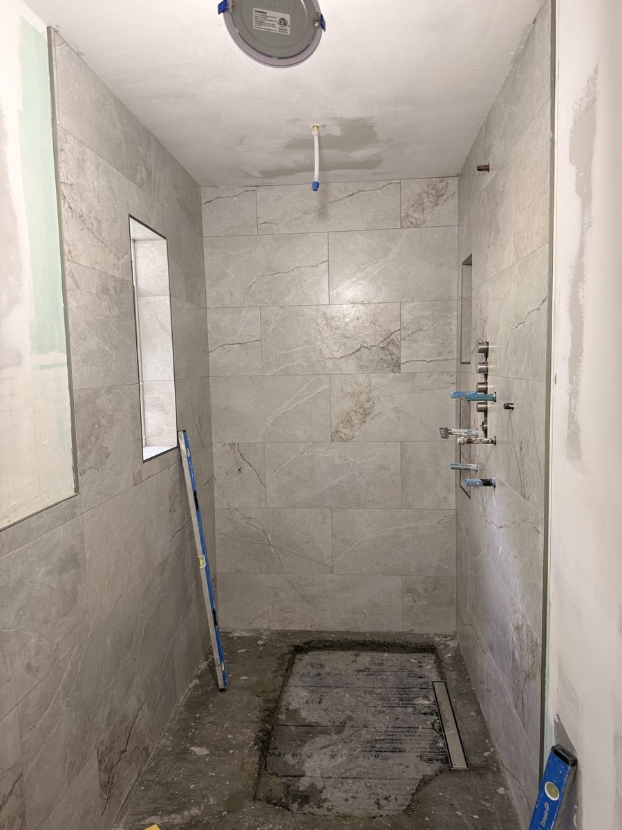 Marble-look tile shower with niche